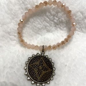 Cream beaded, stretch bracelet with upcycle charm. New, never worn.